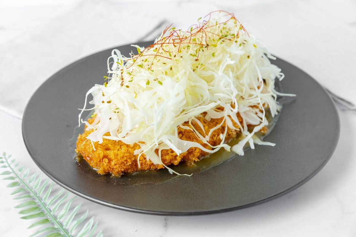 千切りキャベツをのせた揚げ物のイメージ写真